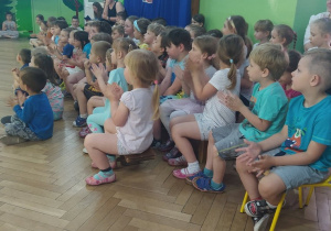 Dzieci siedzą i słuchają muzyki