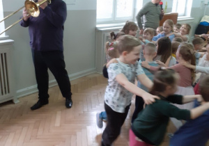 Muzyk gra na puzonie a dzieci jadą pociągem