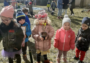 Pan Jacek pomaga dzieciom posadzić wygrana roślinkę