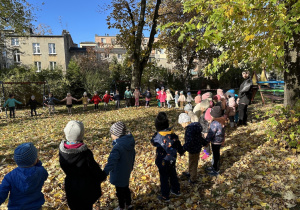 Wszystkie dzieci stoją w ogrodzie w kółku i śpiewają piosenkę