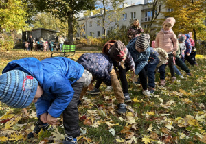 dzieci stoją jedno z drugim i podają ziemniaki pod nogami