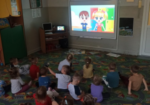 Dzieci oglądają film edukacyjny na dużym ekrania