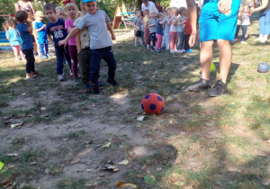 Chłopiec kopie piłkę do bramki