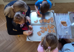 Dzieci z bliskimi dekoruja pierniczki