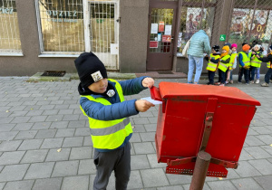 Dziecko wrzuca swój list do skrzynki pocztowej