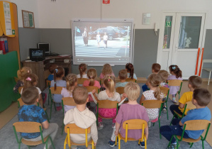 Dzieci oglądają film edukacyjny dotyczący bezpiecznego przechodzenia przez ulicę