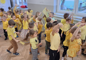 Dzieci obracają się trzymając żółte chusteczki w górze. Wykonują zadania z piosenki