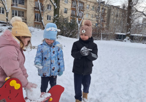 Dzieci próbują ulepić bałwana