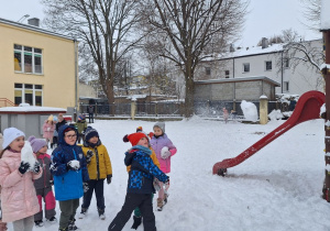 Dzieci rzucają kulkami ze śniegu do celu