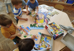 Dzieci układają puzzle przy stoliku