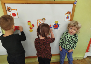 Na tablicy dzieci układają wzory wg wylosowanego zadania