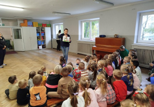 Dzieci siedzą i słuchaja bajki o ziemniaku opowiadanej przez nauczycielkę