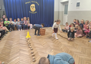 Sadzimy ziemniaki - dwoje dzieci czyli reprezentacja grupy układają ziemniaki w rzędzie na czas