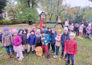 Zdjęcie grupowe dzieci z grupy IV z workiem ziemniaków, które zebrali