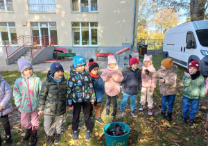 Dzieci stoją i słuchają informacji o alpakach