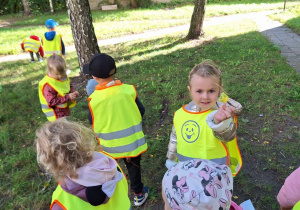 Dzieci zbierają liście pod brzozą