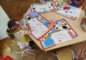 Dzieci za pomocą paluszków i farb tworzą wspólny obraz