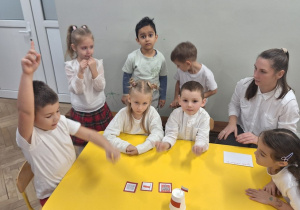 Dzieci pokazują wybrane obrazki przedstawiające symbole narodowe