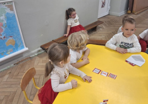 Dzieci pokazują wybrane obrazki przedstawiające symbole narodowe