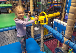 Dziewczynka stoi przy armatce na piłki