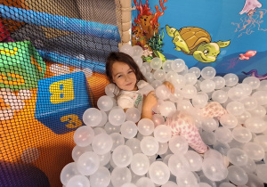 Dziewczynka siedzi w piłkach