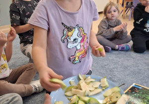 Dziewczynka bierze jabłko do degustacji