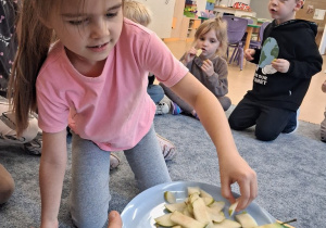 Dziewczynka bierze jabłko do degustacji