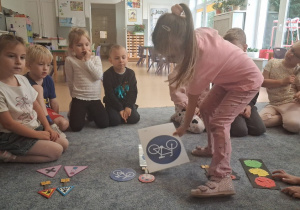 Dziewczynka segreguje znaki drogowe według kształtu