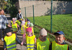 Dzieci idą parami po chodniku