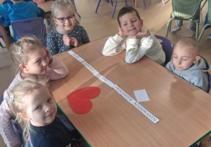 Dzieci przy stolikach układają napis - mam prawo być szanowanym i kochanym