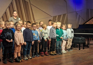Dzieci pozują do zdjęcia przy fotepianie