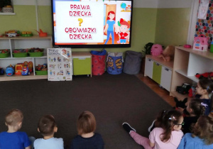 Dzieci oglądają film edukacyjny na ekranie o prawach dziecka