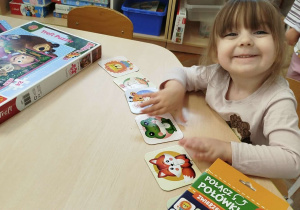 Dziewczynka układa puzzle łącząc je w pary