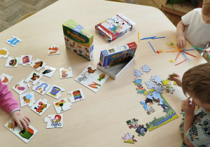 Dzieci przy stoliku bawią się wg swoich zainteresowań