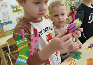 Chłopiec paruje skarpetki wieszając je na sznurku