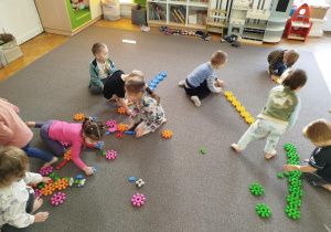 Dzieci na dywanie szukały klocków w odpowiednim kolorze