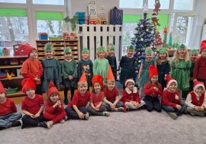 Zdjęcie grupowe dzieci przy choince w strojach choinek i krasnali