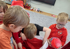 Dzieci wyciągają prezenty z worka Mikołaja