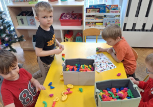 Dzieci bawią się zabawkami otrzymanymi w prezencie na Mikołajki