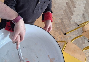 Dziecko trzyma klucz, nauczycielka leje wosk przez dziurkę