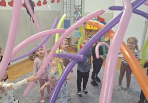 Dzieci bawią się i tańczą z długimi balonami