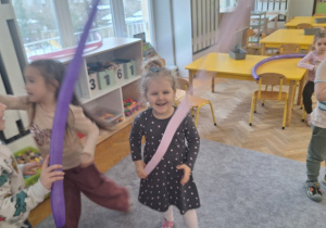 Dzieci bawią się i tańczą z długimi balonami