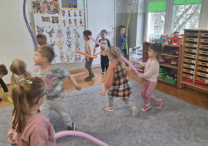 Dzieci bawią się i tańczą z długimi balonami
