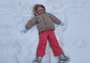 Dzieci robią aniołki na śniegu