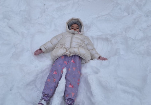 Dzieci robią aniołki na śniegu