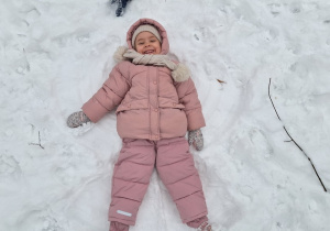 Dzieci robią aniołki na śniegu