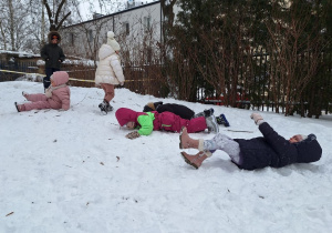 Dzieci turlaja się z górki